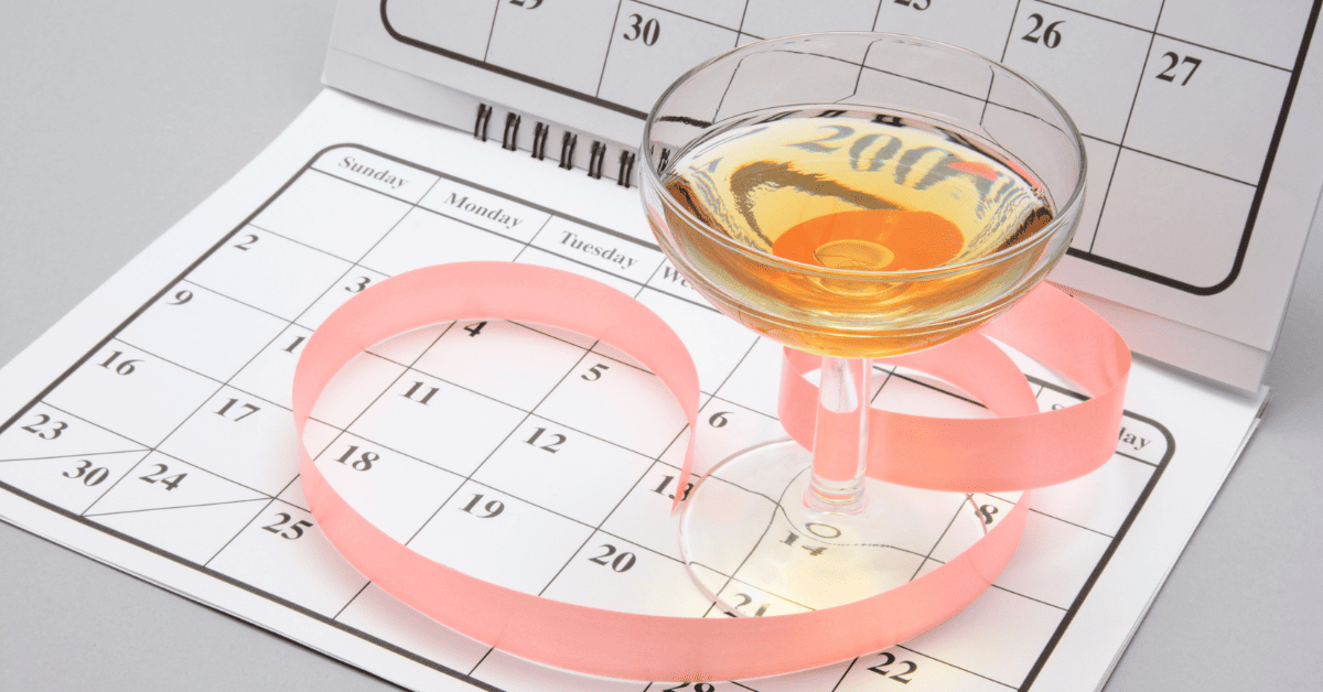 Calendário de datas com uma taça de vinho em cima.