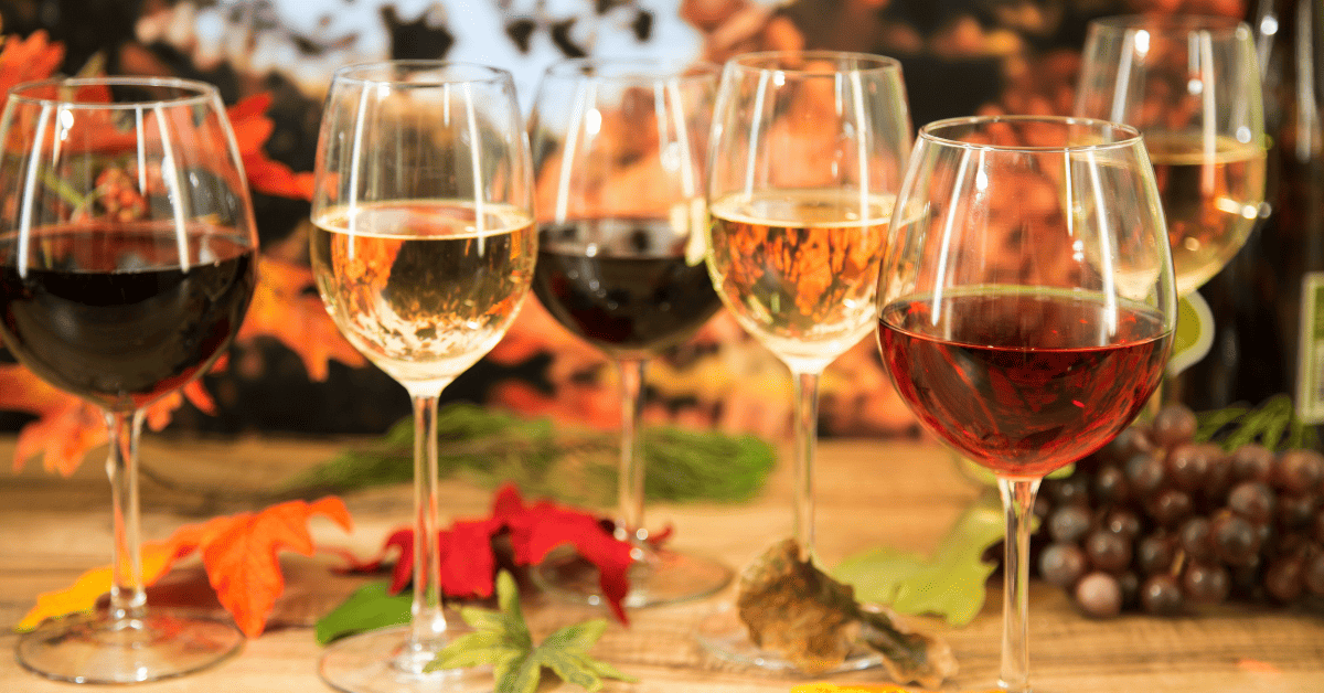 Taças de vinho em uma mesa com folhas secas de outono.
