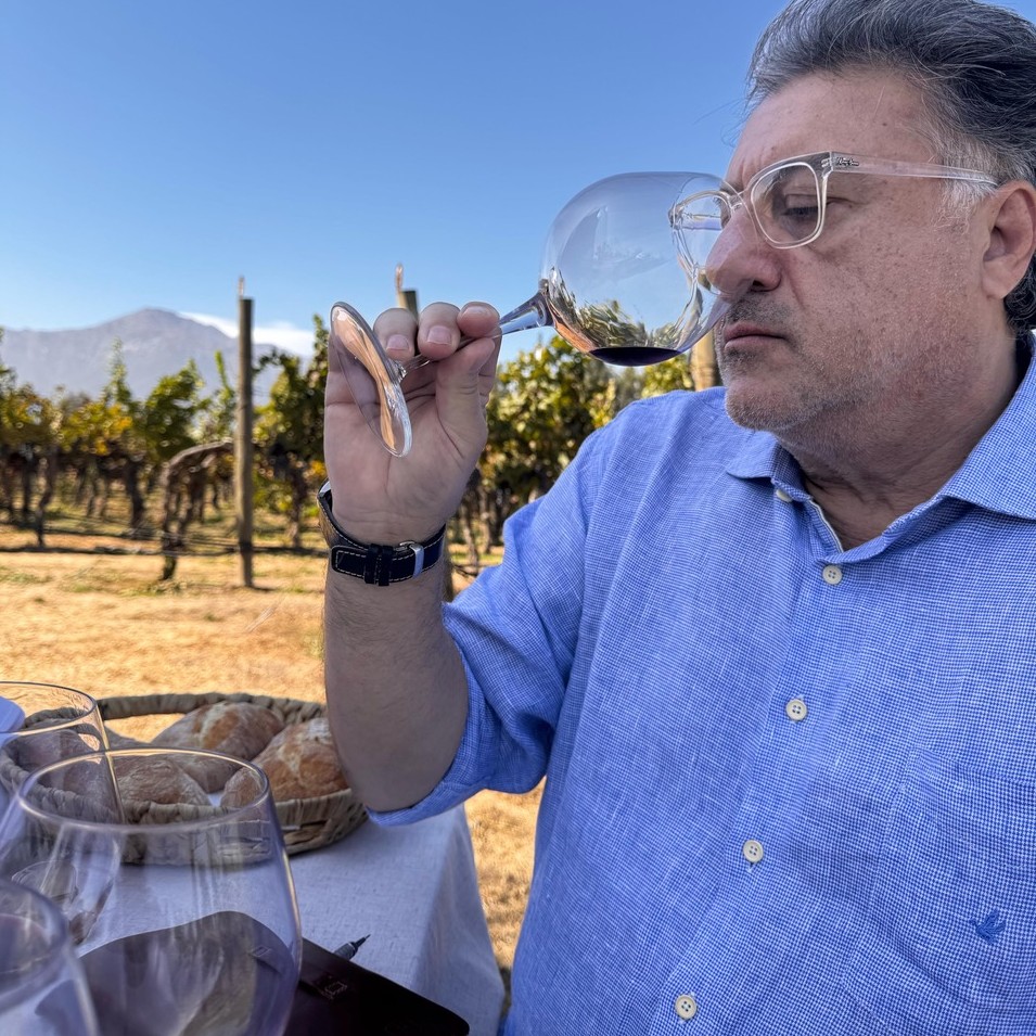 Wine hunter Vicente Jorge tomando vinho em um vinhedo no Chile.