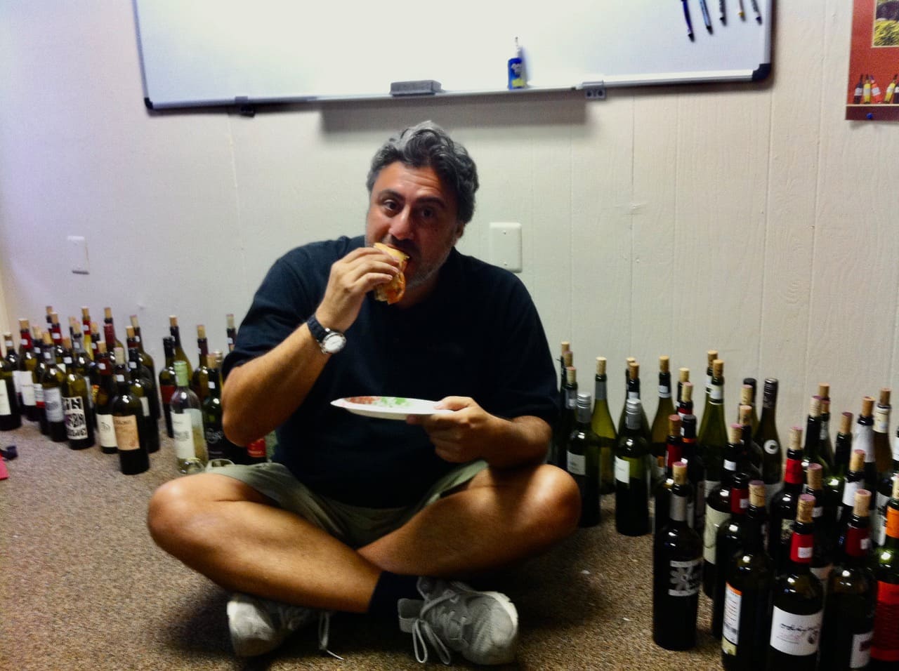 Vicente Jorge sentado no chão em uma degustação inusitada.
