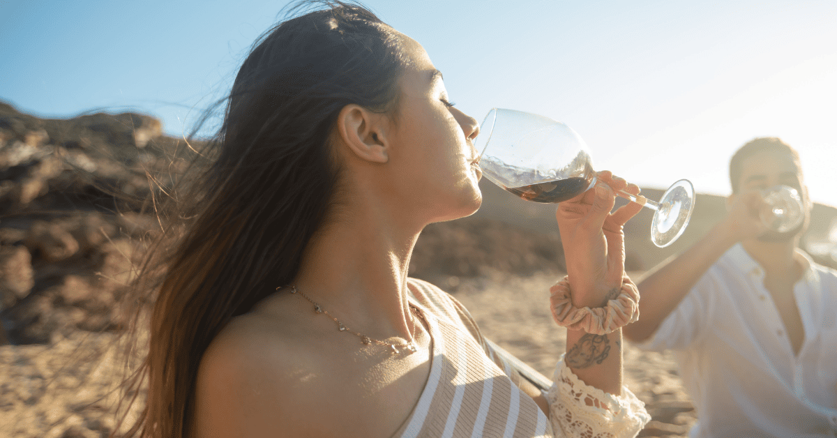 Mulher bebendo vinho tinto.