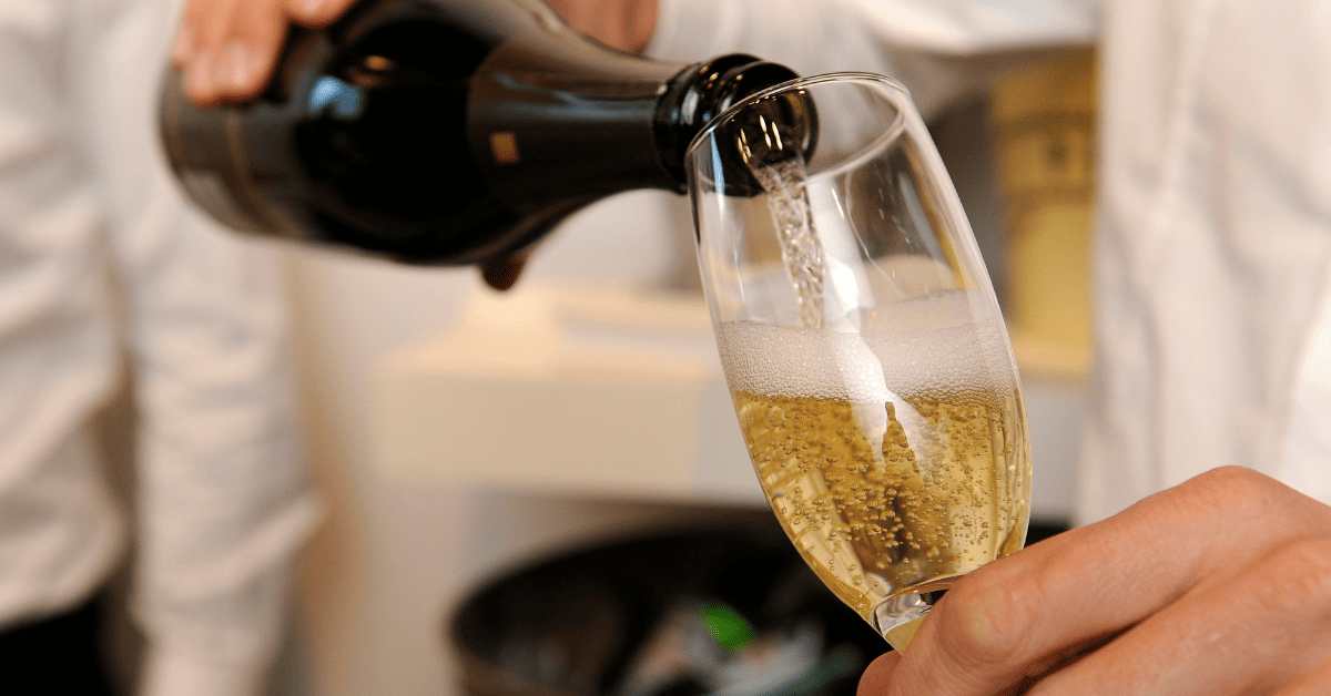 Taça de espumante sendo enchida de Cap Classique.