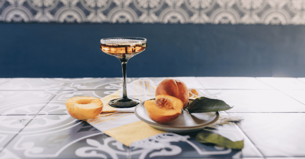 Taça de vinho com frutas frescas cortadas.