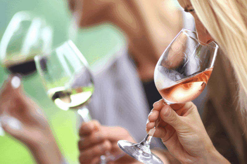 Três pessoas segurando taças de vinho.